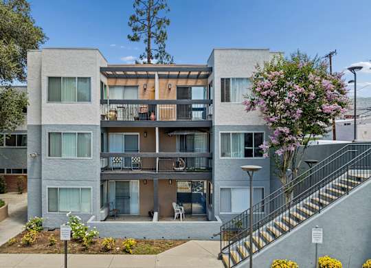 Apartment building with a tree in front of it.