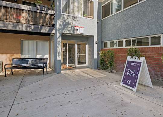 A sign in front of a building says "This Way".