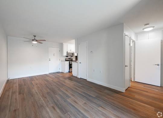 A room with a ceiling fan and wooden flooring at Oak Park Apartments, Monrovia, 91016