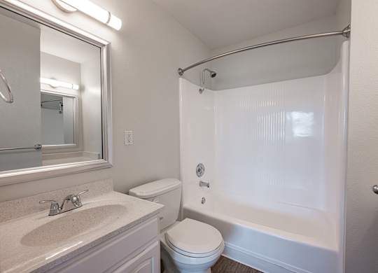 A white bathroom with a toilet, sink, and shower at Oak Park Apartments, Monrovia, 91016