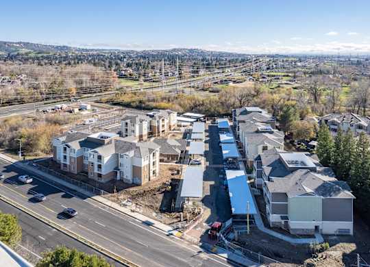 A road with cars and apartment buildings.