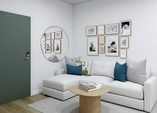 A white couch with blue pillows sits in a room with a coffee table in front of it.