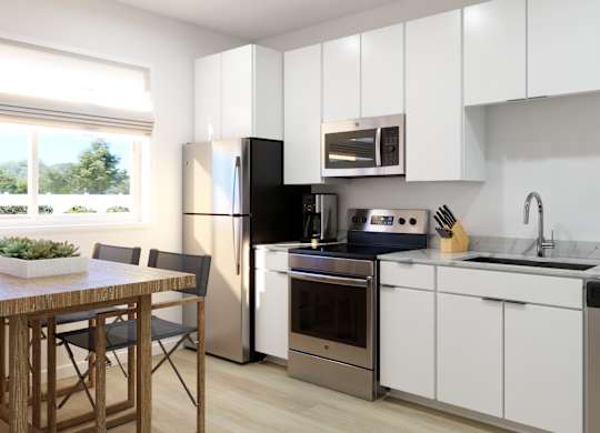 A modern kitchen with white cabinets and stainless steel appliances.