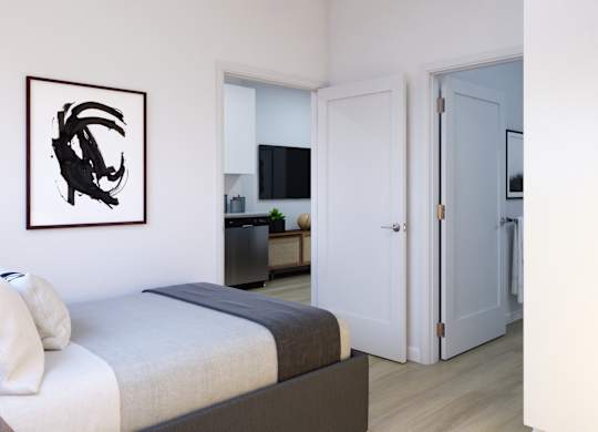 A bedroom with a bed, a painting, and a door leading to another room.