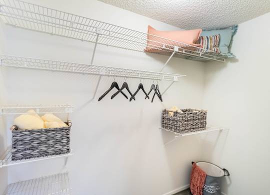A white closet with shelves and hangers at Chaparral Apartments, Palmdale 93551
