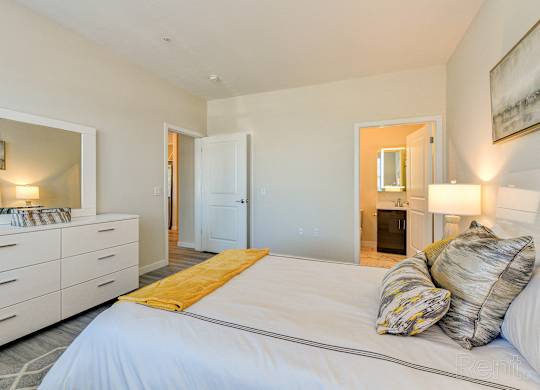 a bedroom with a large white bed and a bathroom at Solo at North Bergen, North Bergen, New Jersey