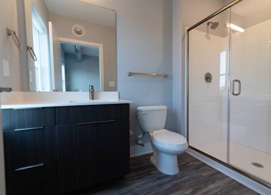 A modern bathroom with glass shower doors at Novi Flats Apartments in Concord, NC