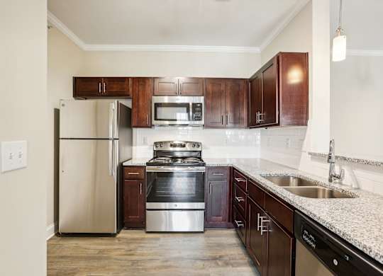 a kitchen with wooden cabinets and stainless steel appliances