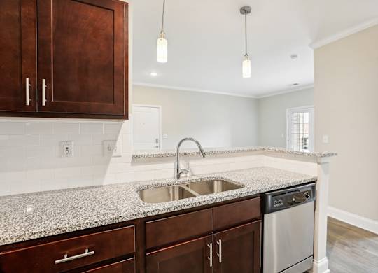 a kitchen with granite counter tops and a stainless steel sink