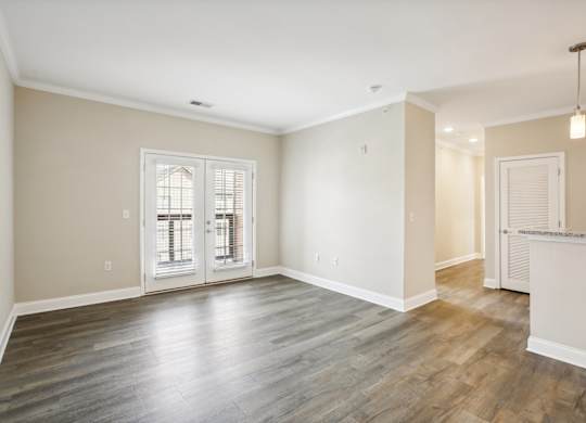 the living room and dining room in a new home with white walls and wood floors
