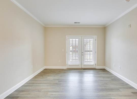 an empty living room with white walls and doors