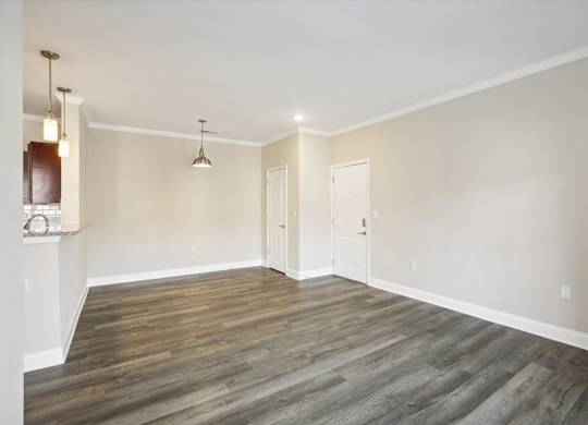 an empty living room with wood floors and white walls