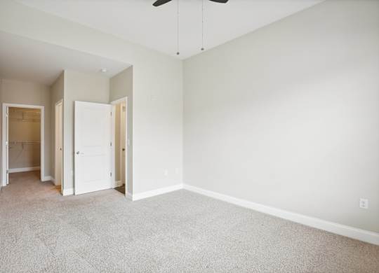 an empty room with white walls and a ceiling fan