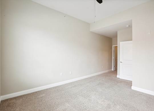 an empty living room with white walls and carpet