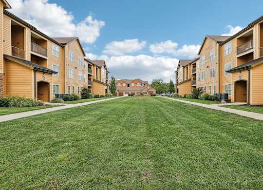 a green lawn in front of a row of houses
