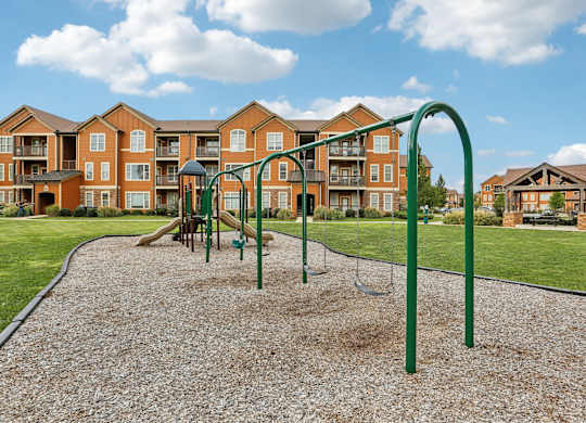 an empty playground with an apartment building in the background