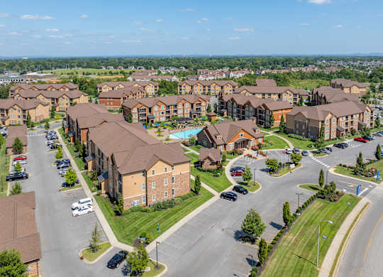 an aerial view of an apartment complex with cars parked in a parking lot