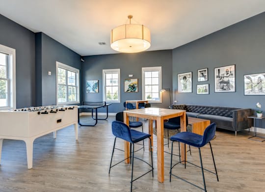 Resident lounge and game room with seating and entertainment space at The Rail North Bergen apartments
