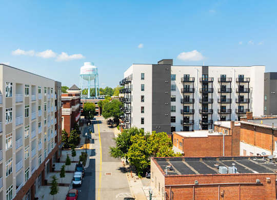 A view of a street with apartment buildings on both sides.