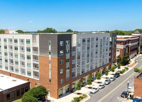 A large multi-story building with a parking lot in front.