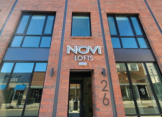 The front of a building with the name NOVI LOFTS on it.
