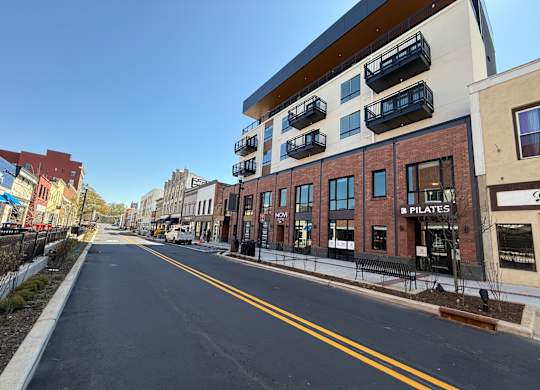 A street view with a building that has a sign that says "PILATES".