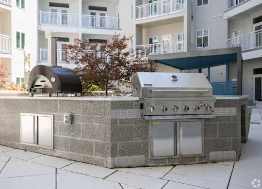 A modern outdoor kitchen with a grill and sink.