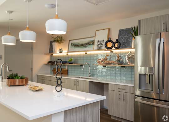 Stylish resident lounge at NOVI at Concord featuring contemporary seating, stainless steel appliances, and modern lighting accents