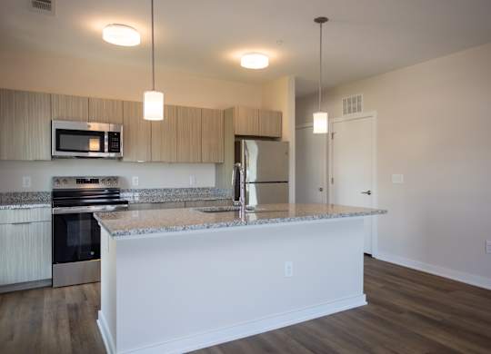 A kitchen with granite countertops and white cabinets.