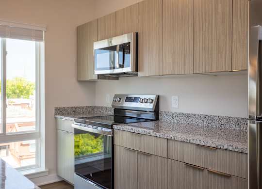 Modern kitchen with stainless steel appliances at NOVI at Concord.