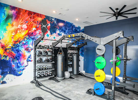 A gym with a blue wall and a ceiling fan.