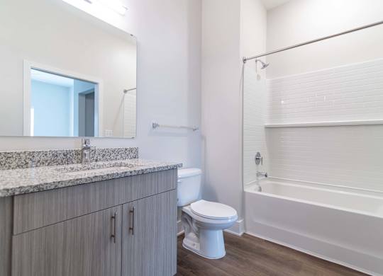 Spa-like bathroom with granite vanity top and soaking tub at Novi Rise Apartments in Concord, NC