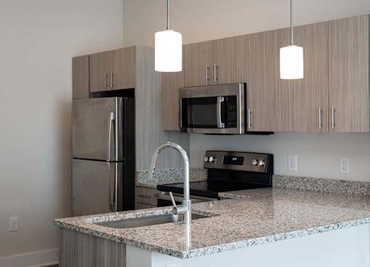 A kitchen with granite countertops and stainless steel appliances at Novi Rise Apartments in Concord, NC