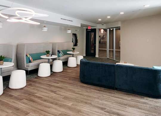A modern waiting area with a blue sofa and white chairs.