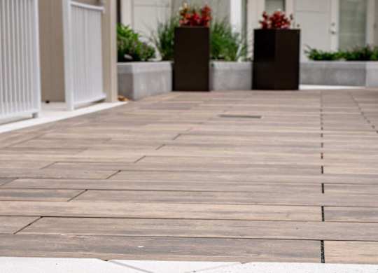 A wooden walkway leads to a white door.