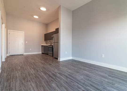 A kitchen area with a refrigerator, sink, and cabinets.