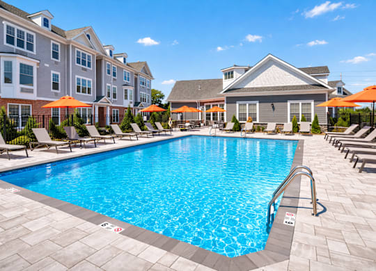 Resort style swimming pool and outdoor seating at The Rail North Bergen apartments