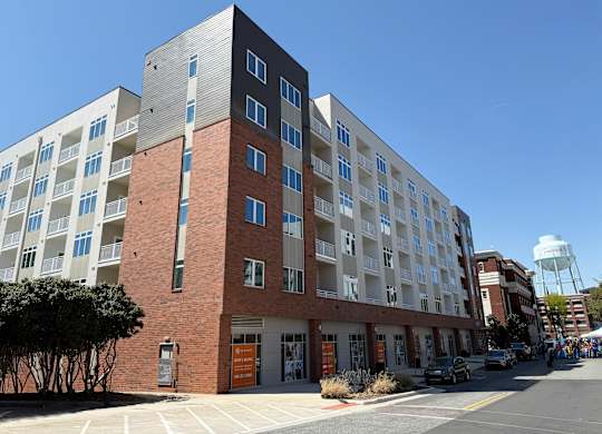 A large multi-story building with a parking lot in front.