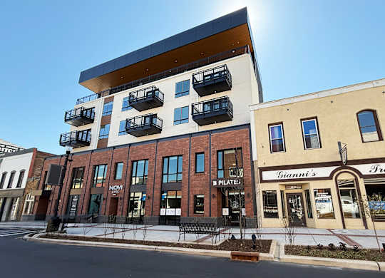 A modern building with balconies on the upper floor.