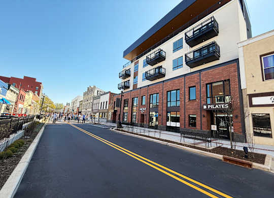 A street view with a building that has a sign that says "PILATES".