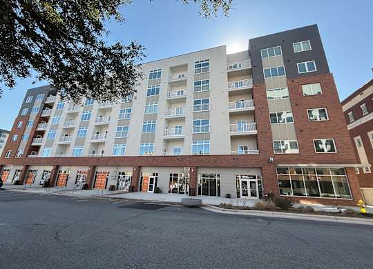 A large multi-story apartment building with a parking lot in front.
