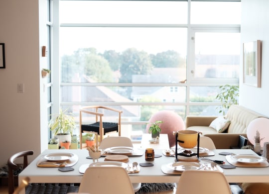 a dining room with a table and chairs in front of a window
