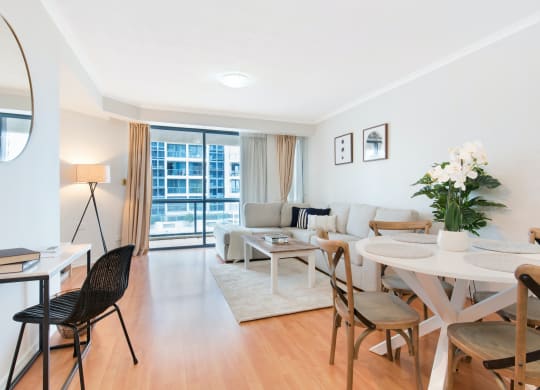 a living room and dining room with a table and chairs