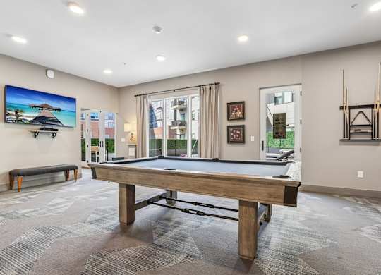 A room with a pool table and a bench.