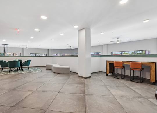 A spacious room with a long table and chairs.