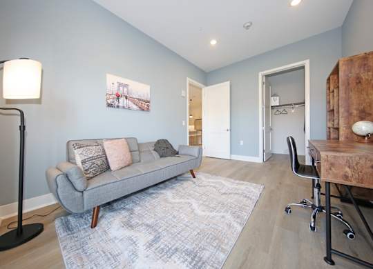 A living room with a grey couch and a wooden table.