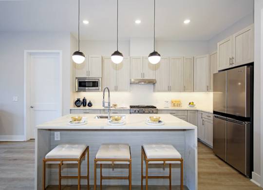A kitchen with a white island and stools.