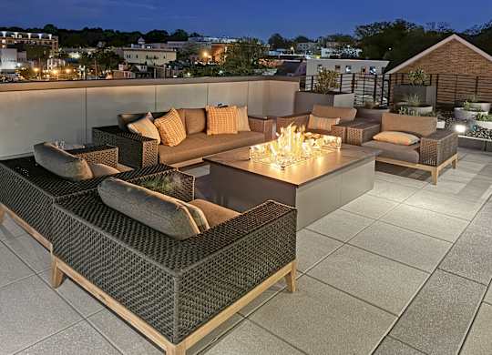 A rooftop patio with a couch and a firepit