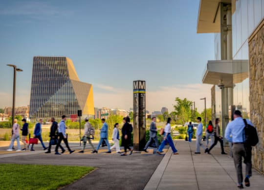 People walking on a sidewalk in front of a building.