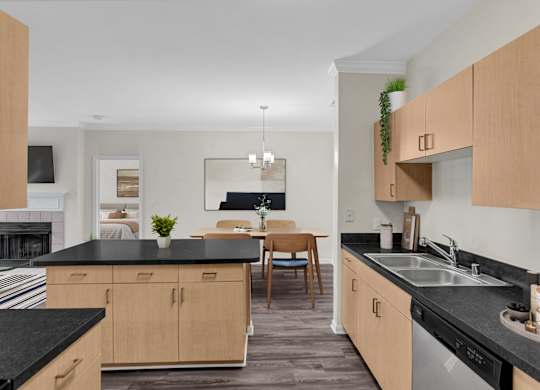 A kitchen with black countertops and wooden cabinets.